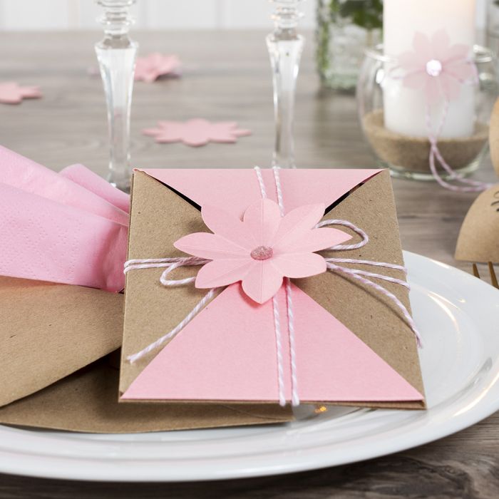Invitasjon pakket inn og lukket med snor og utstanset blomst