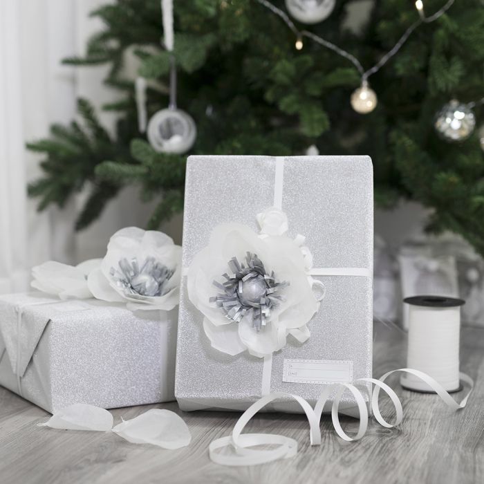 Gaveinnpakning pyntet med blomst av silkepapir