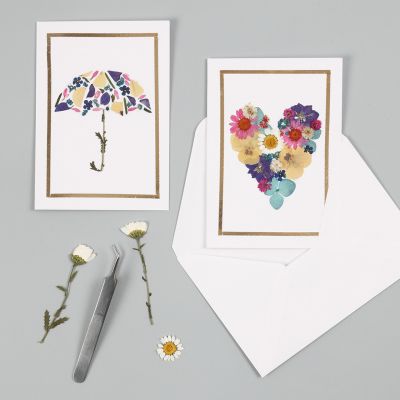 Kort med motiver laget av tørkede blomster og ramme av dekorasjonsfolie