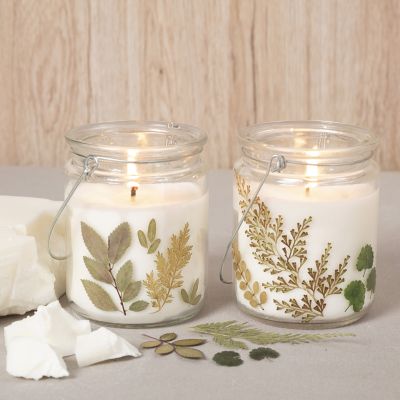 Lys av rapsvoks av glass med t&oslash;rkede blomster